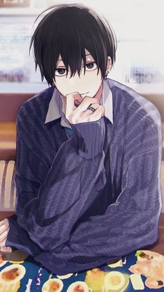 the image shows a young man with short, black hair and dark eyes. he is wearing a purple cableknit sweater over a white collared shirt. he is sitting down, and his right hand is resting on his chin in a thoughtful gesture. the background is blurred, suggesting an indoor setting. the lighting is soft, giving the image a warm and inviting feeling.