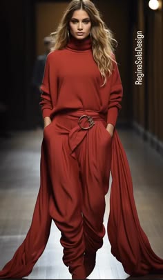 a beautiful woman in a red dress with a plunging neckline and a belted waist is posing on a runway. the dress is flowing and elegant, and the woman's hair is styled in a sleek and sophisticated way. the image is taken from a fashion show and captures the essence of high fashion.
