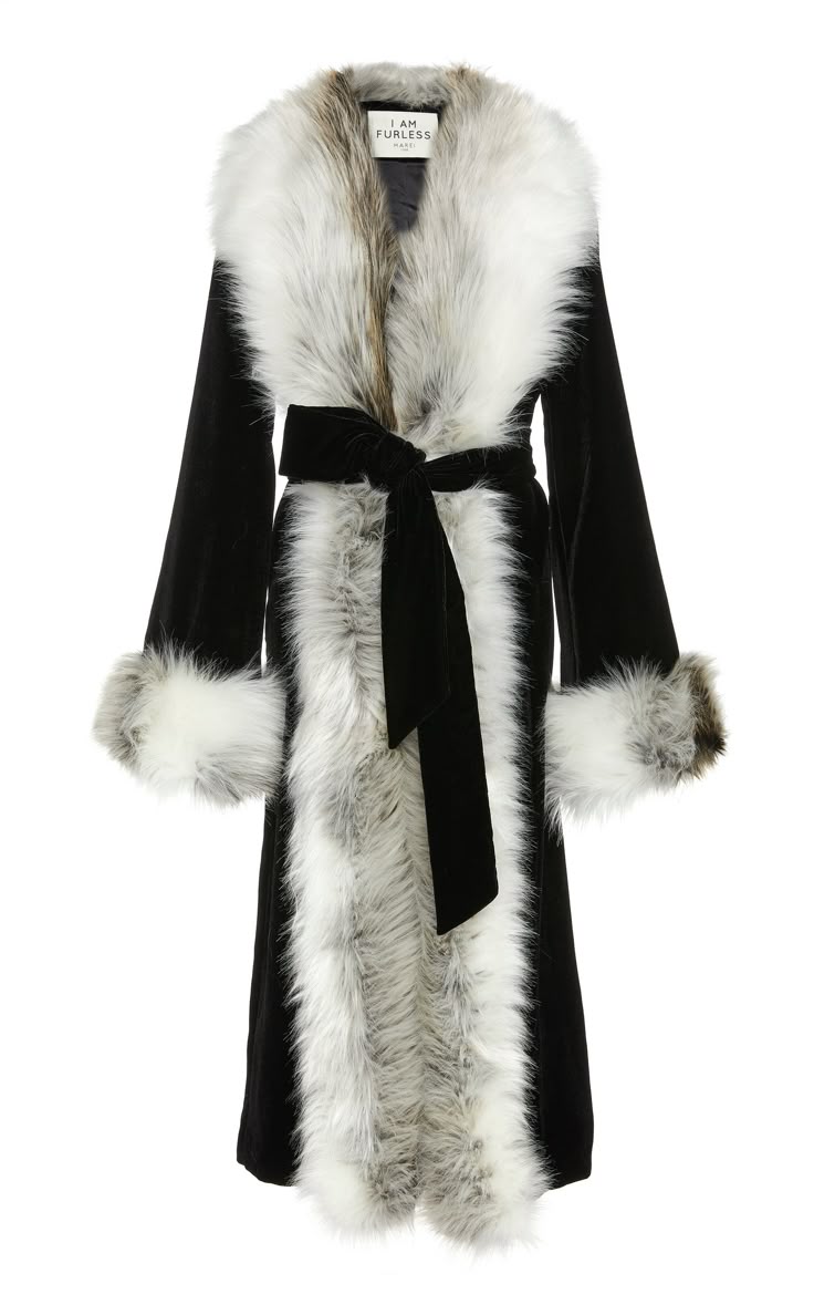 a full shot shows a long black coat with white faux fur trim around the collar, cuffs, and down the front. a black tie cinches the waist.