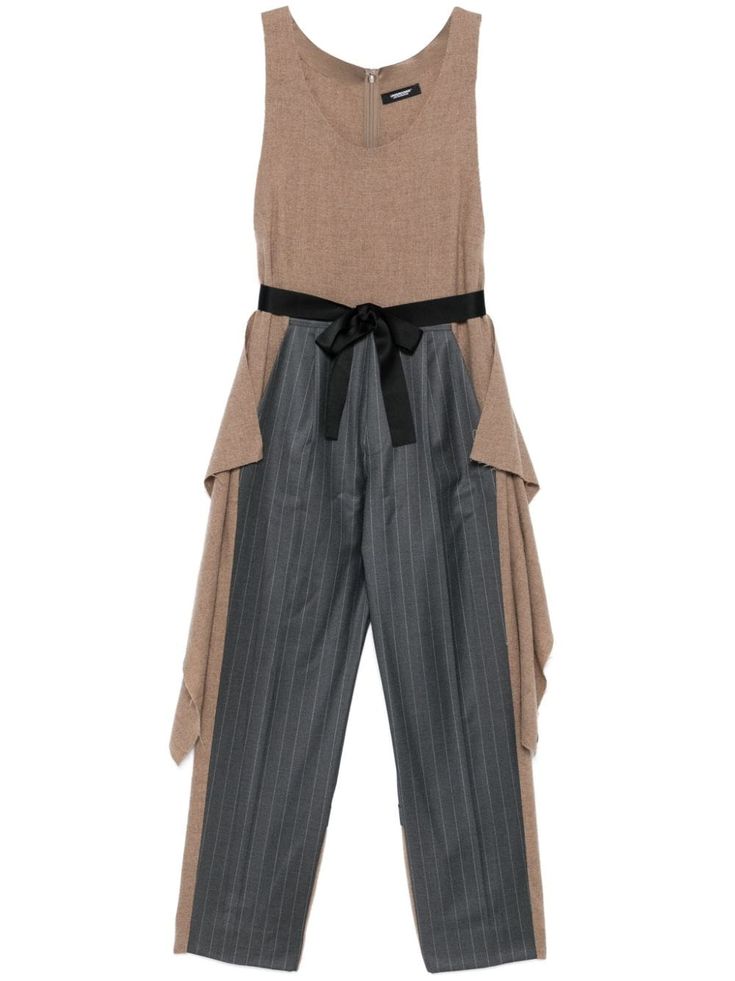 this is a stylish brown and grey jumpsuit with a pinstripe pattern. it has a black sash tied around the waist. the sleeves are draping on the sides and are brown, while the legs are pinstriped grey. the jumpsuit is a modern and elegant piece of clothing that would be perfect for a special occasion.