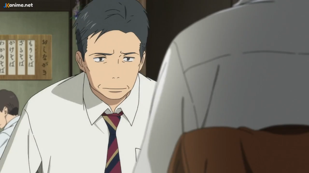 the image shows a scene from an anime. two men are having a serious conversation in a restaurant. the focus is on the man on the left, who has short black hair and is wearing a white shirt with a dark tie. the man on the right is out of focus and only partially visible. the lighting is slightly dim, creating a serious and intimate atmosphere. the overall color palette is warm and muted.
