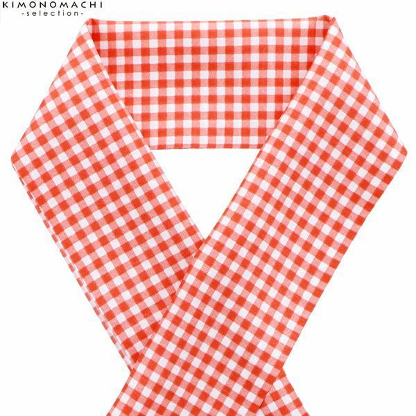 a red and white gingham patterned fabric tie, knotted at the top, lays flat on a white background.
