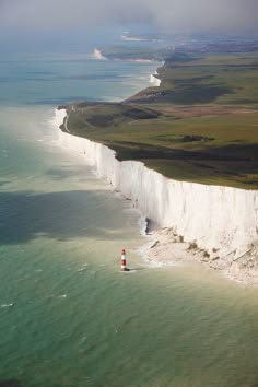 a stunning aerial view of the iconic white cliffs of dover, england. the white cliffs rise up dramatically from the turquoise waters of the english channel. the cliffs are a popular tourist destination and a symbol of england.
