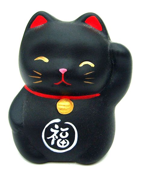 closeup view of a small, black ceramic manekineko (beckoning cat).  the cat is depicted with a raised right paw, a red collar, a gold bell, and the kanji character for "福" (fuku, meaning happiness or fortune) on its belly. its face is painted with simple features, including smiling eyes and whiskers. the overall style is cute and traditional japanese. the figurine appears to be made of a mattefinished material.