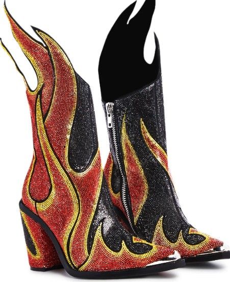 two cowboy boots with flame designs are displayed against a white background. the boot on the left is predominantly red with yellow outline and black flame accents. the boot on the right is primarily black with a zipper and similar flame design. both boots have high heels and pointed toes with metal tips.