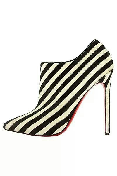 a black and white striped high heel shoe with a red sole. the shoe is a stiletto heel and has a pointed toe. the shoe is very stylish and elegant.