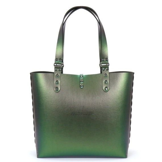 this is a beautiful green leather tote bag. it has a large main compartment and two shorter top handles. the bag is made from high quality leather and has a glossy finish. it is perfect for everyday use or for special occasions. the bag also features a subtle logo on the front.