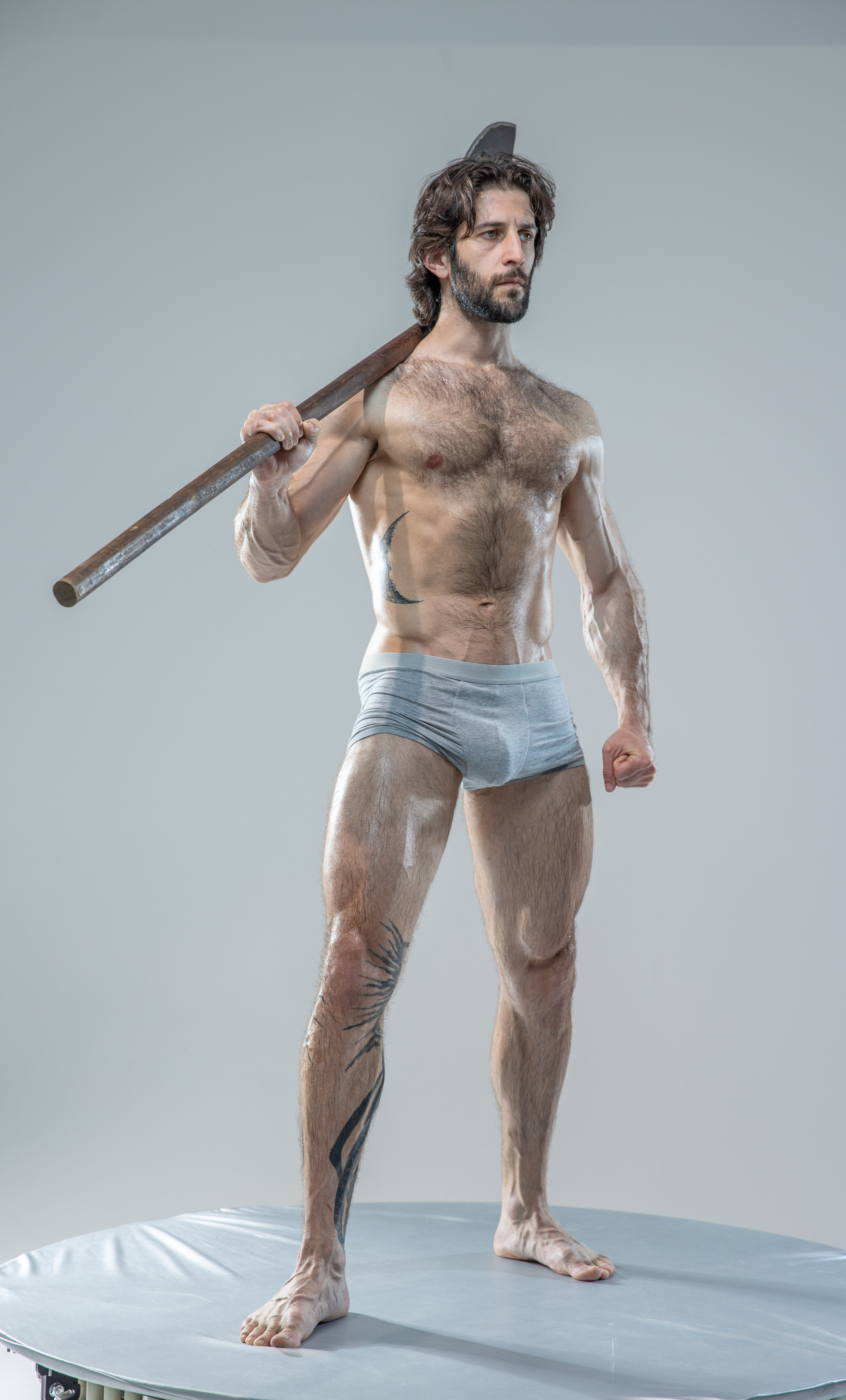 a muscular man with an axe stands on a circular platform against a gray background.