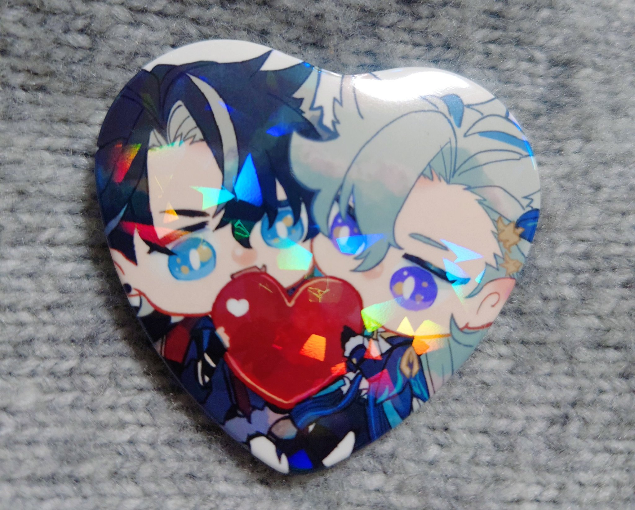a holographic heartshaped pin featuring two anime boys from genshin impact, itto and albedo, with a red heart in the middle. itto is on the left, while albedo is on the right. they are both smiling and look happy. the pin is very detailed, with a lot of color and shimmer.