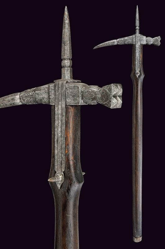 the image shows two lucerne hammers against a dark background. the lucerne hammers are polearms featuring a hammerhead on one side, a spike on the other, and a long pole haft made of wood. the metal parts are decorated with engravings. the pole has some decorative spikes, and the bottom of the pole is capped with metal.
