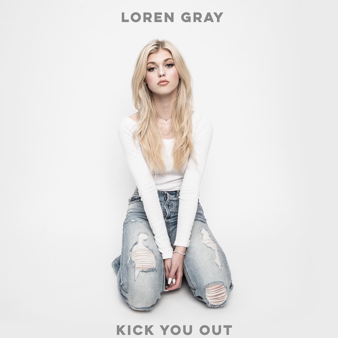 the image is an album cover featuring the singer loren gray. she is kneeling on a white surface, wearing a white longsleeved top and ripped blue jeans. she has blonde hair and is looking directly at the camera. the text "loren gray" is at the top of the image, and "kick you out" is at the bottom.