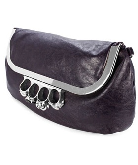a dark purple leather handbag with a silver frame and a knuckle duster design featuring four rings and skull detailing.