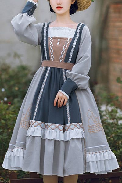 a woman wearing a vintage style dress with ruffles and embroidery. she is posing against a backdrop of greenery. the dress features a square neck, puff sleeves, and a flowing skirt.