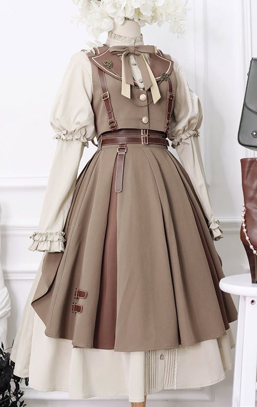a fulllength image of a brown and beige steampunk lolita dress displayed on a mannequin. the dress has intricate details such as leather straps, buckles, and buttons. the mannequin is positioned in front of a white wall with a floral arrangement on top.
