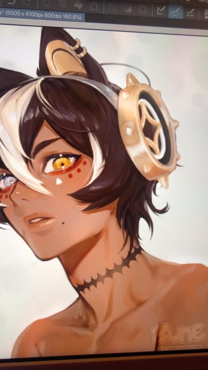 the image shows a closeup digital painting in progress of a male animestyle character. the character has dark brown and white hair styled in a way that partially obscures one ear,  tan skin, catlike ears adorned with gold bands, and large, expressive golden eyes accented with red dots. they also wear a large, gold, steampunkinspired headset/headpiece. a black, jagged, chokerstyle tattoo is visible around their neck. the overall style leans towards fantasy, with a sophisticated and detailed rendering. the image appears to be on a digital art program display, with the software interface partially visible at the top.  a watermark or artist signature ("rune") is also visible in the lower right corner.