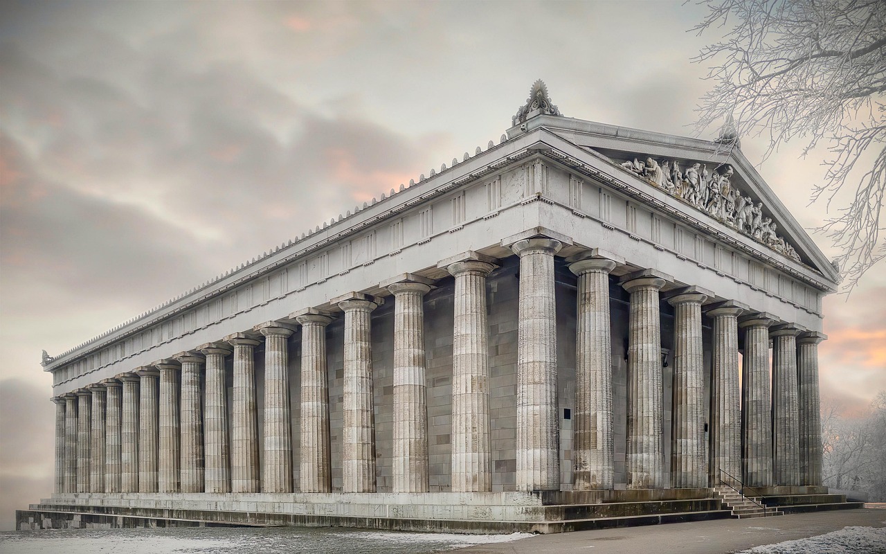 the image showcases the walhalla temple, a striking neoclassical structure adorned with doric columns. the building's grand facade is crafted from stone, standing majestically against a cloudy sky. it's an impressive architectural landmark, capturing the essence of german and european architectural heritage.