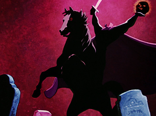 the image is a still from an animated film, likely a halloweenthemed piece, depicting the headless horseman. he's riding a dark horse, silhouetted against a crimson backdrop. he carries a sword in one hand and a glowing jacko'lantern in the other. the setting is a graveyard with shadowy tombstones. the overall style is dark, spooky, and evocative of classic halloween imagery.  the color palette is predominantly dark reds and purples, enhancing the ominous atmosphere. the animation style is somewhat stylized, with strong silhouettes and dramatic lighting.
