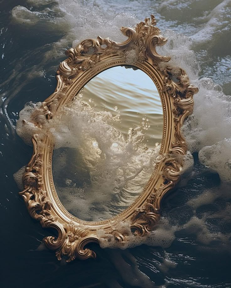an ornate goldframed mirror is positioned in water with waves crashing around it. the mirror reflects the water, creating a surreal and dreamlike image. foam from the waves clings to the frame.