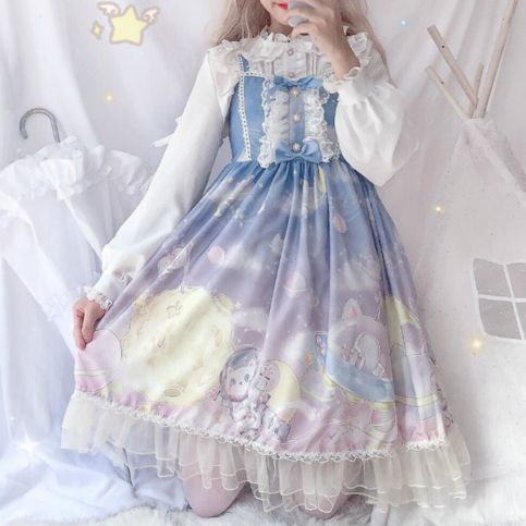 a young woman poses in a bedroom while wearing a lolita fashion dress. the dress is blue and purple with a print of stars, clouds, a moon, an astronaut, and a bunny. the dress is adorned with ruffles and lace, and the woman has her hair styled in loose curls. the room is decorated in a soft, feminine style with white furniture and pastel colors. the overall effect is sweet and romantic.