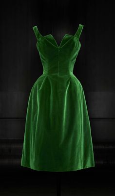 a beautiful emerald green velvet dress with a simple sweetheart neckline and a full skirt. the dress is sleeveless and has a classic silhouette that is both elegant and timeless. it is perfect for a special occasion or evening out.