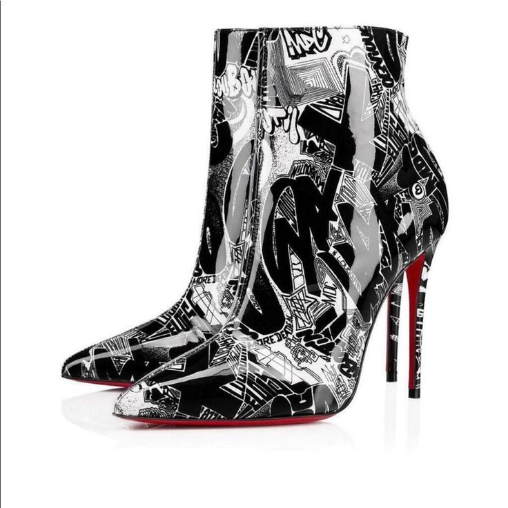 the image showcases a pair of christian louboutin ankle boots.  they are highheeled stilettos with a pointed toe. the boots are made of patent leather and feature a striking black and white graffiti print covering the entire surface. the iconic red louboutin soles are visible on the bottom. the boots are presented at a slight angle, showing both shoes. the background is plain white, allowing the shoes to be the focal point of the image. the overall style is bold and edgy.