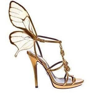 a pair of gold butterfly sandals. the sandals are highheeled and have a delicate butterfly wing design on the strap. the sandals are designed for evening wear and would be perfect for a special occasion.