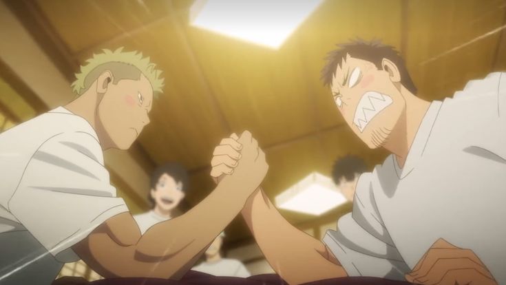 two men are fiercely engaged in an armwrestling match. the perspective is from a low angle, looking up at the competitors. the room is brightly lit with a warm, yellowish light, and several onlookers are visible in the background, their faces blurred. the man on the left has short blond hair and a determined expression, while the man on the right has darker hair and a more strained expression. both men are sweating from the effort.