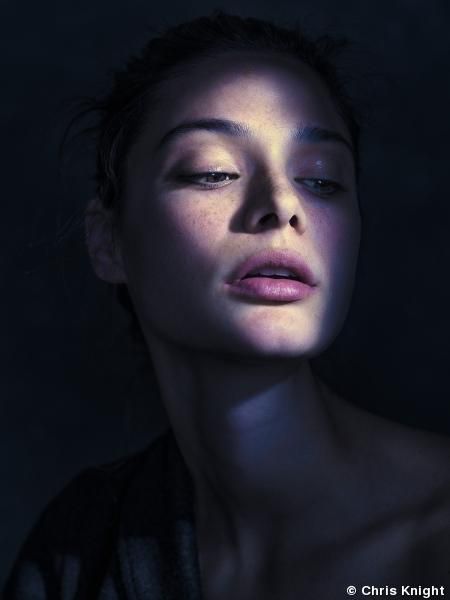 a close up portrait of a woman's face. the woman is looking at the camera. her eyes are closed and her lips are parted. the image is in black and white and is lit from the side, creating a dramatic effect. the woman's face is framed by dark hair. the image is a powerful and sensual portrait.