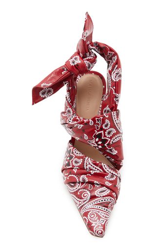 a pair of women's red and white bandana print pointedtoe heels. the shoes are made of leather and have a pointed toe. they are tied at the ankle with a bandanaprint bow. the shoes are a stylish and luxurious item.