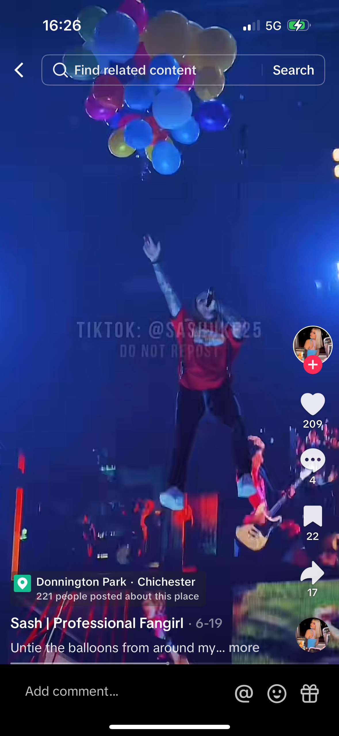 the image is a screenshot of a tiktok video featuring a professional fangirl at a concert. she is wearing a red shirt and black pants, and she is holding a microphone. she is standing on a stage, and there are balloons in the air. she is smiling and looking at the camera, she is clearly enjoying the show and the music. the audience is also visible in the background. there are comments and hearts in the lower right corner of the image, these are all positive interactions from other viewers of the video.