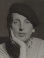 the image is a black and white closeup portrait of a woman. she is wearing a darkcolored beret and a lightcolored, possibly knitted, sweater or top.  her hand is gently resting on her chin, and she has a thoughtful or contemplative expression on her face. the lighting is soft and diffused, characteristic of studio portraiture from the early to mid20th century. the overall style suggests a vintage or classic photograph, possibly from the 1930s or 1940s. the woman's gaze is directed slightly upward, adding to the contemplative mood of the picture. the focus is sharp on her face and hand, with a slightly softer focus on her shoulders and the background, which is subtly out of focus.  the image's aesthetic evokes a sense of elegance and sophistication.