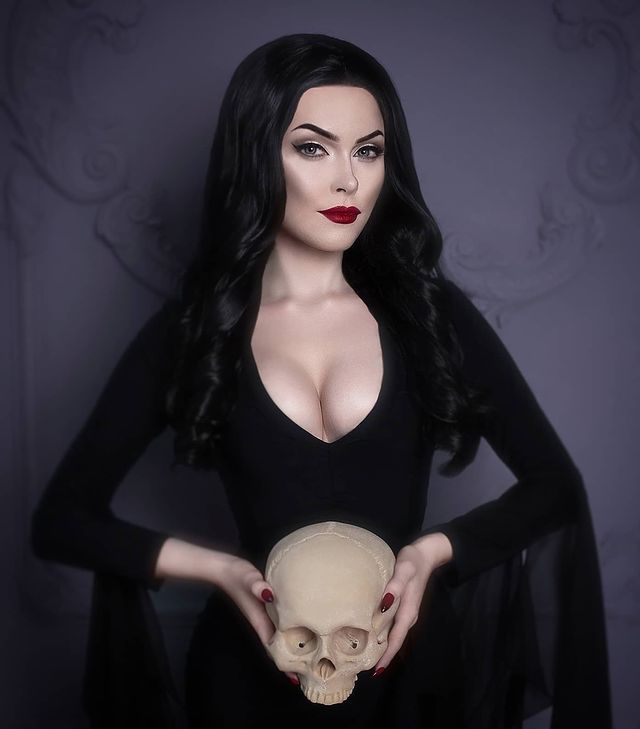 a woman is wearing a long black dress with