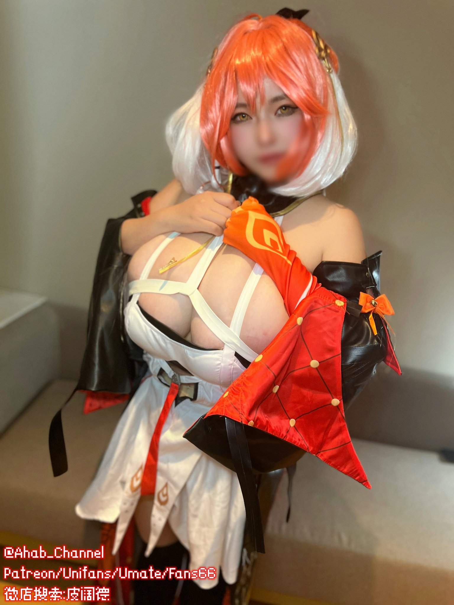 a closeup shot of a woman cosplaying as klee from the video game genshin impact. she's wearing a detailed, accurate costume, including a red and white outfit, a vibrant red wig styled similarly to klee's hair, and a confident expression.  the cosplay is suggestive and revealing, emphasizing her cleavage. the background shows a blurred hotel room.  social media handles are visible in the lower left corner.