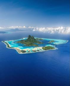 a breathtaking aerial view of a tropical island in the middle of a crystalclear ocean. the island is surrounded by turquoise blue water and white sandy beaches. the sky is a deep blue, and fluffy white clouds drift lazily overhead. the island is lush and green, with palm trees swaying in the breeze. this is a pictureperfect paradise that would be the perfect destination for a relaxing vacation.