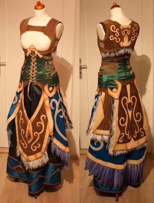 the image shows a detailed front and back view of an elaborate fantasy cosplay costume.  the costume is a long gown with a corsetstyle bodice, layered pieces that resemble armor, and fur trim. the colors are primarily teal, brown, and gold. the design is intricate with ornate patterns and featherlike details at the hem. the costume is displayed on a dress form mannequin against a lightcolored background. the high level of detail and craftsmanship is evident in the construction.