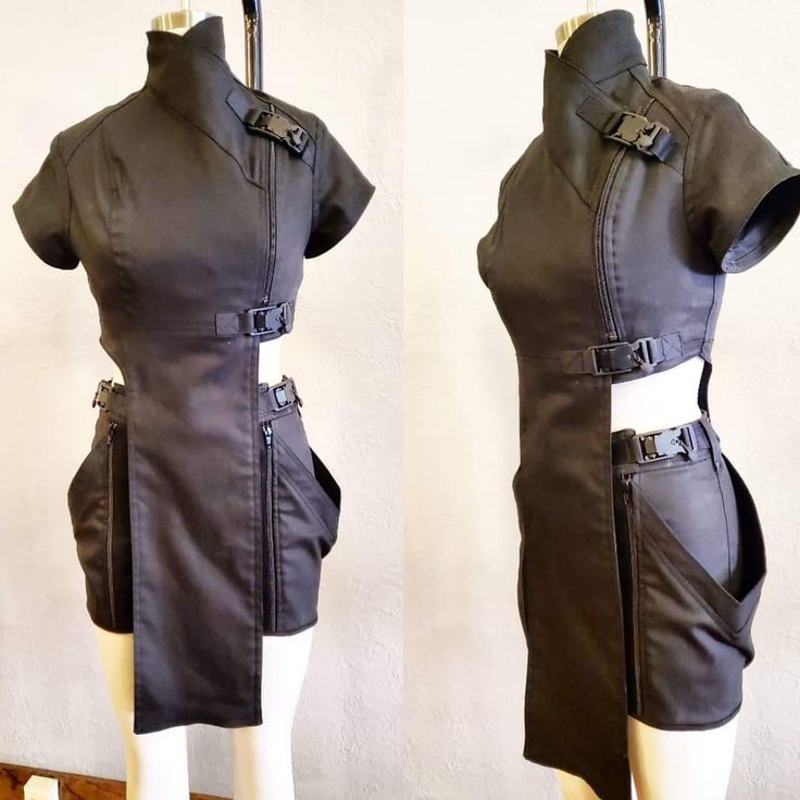 the image shows two views of a dark gray/black futuristicstyle mini dress. the dress features an asymmetrical design with cutouts at the waist, a high mandarin collar, multiple buckles and straps as accents, and zippered pockets. it appears to be made of a sturdy, possibly canvaslike, fabric. the dress is displayed on a mannequin, with one image showing the front and the other showcasing the side profile, to fully display the unique design details.  the overall aesthetic is modern, avantgarde, and suggestive of cyberpunk or dystopian fashion.