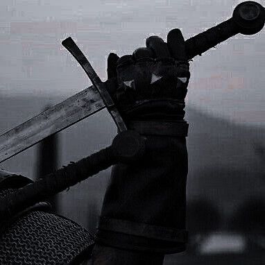 a closeup shot of a knight holding a sword in a dark, ominous setting. the knight is dressed in black armor, and their hand is firmly gripping the hilt of the sword. the blade of the sword is visible in the foreground, and the background is obscured by shadows. the overall tone of the image is dark and foreboding, suggesting a scene of battle or conflict.