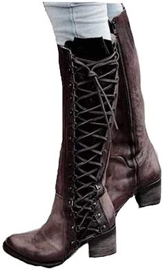 a woman is wearing a pair of brown leather kneehigh boots with laces up the front. the boots have a low heel and a pointed toe. the woman is standing with her feet slightly apart. the background is white.