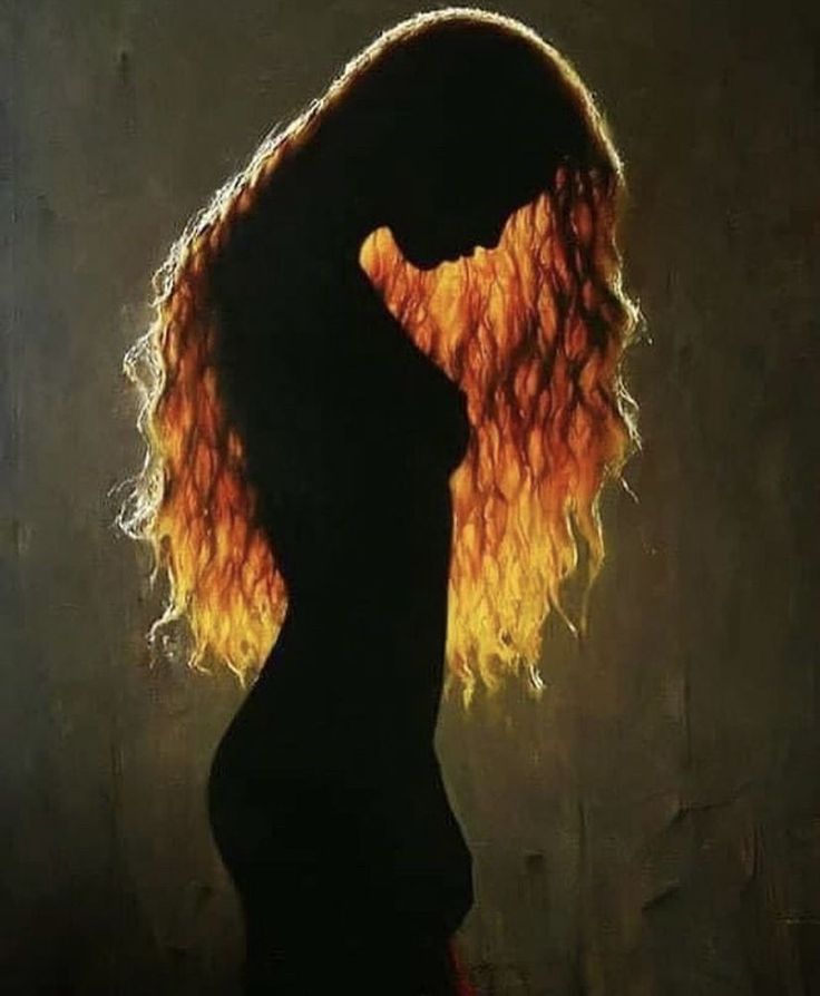 a silhouette of a woman with long, curly orange hair. she is standing in a dark room, with only a sliver of light illuminating her from behind. the image is artistic in style and evokes a sense of mystery, beauty, and sensuality.