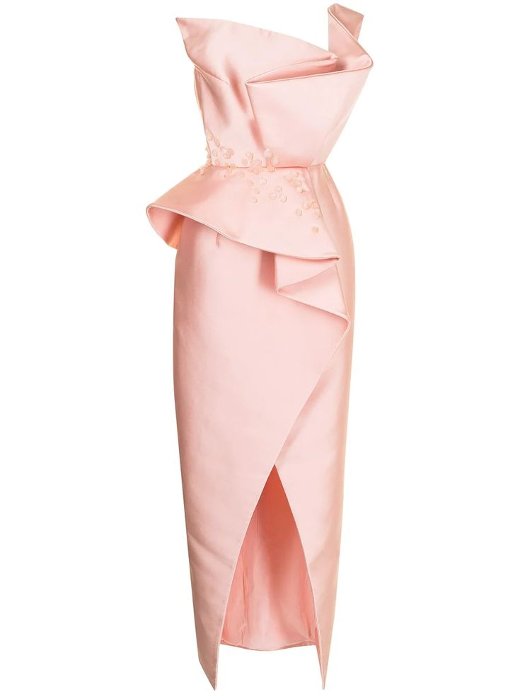 a strapless, pale pink dress featuring an asymmetrical neckline, ruffle detailing, floral embellishments around the waist, and a high slit. the dress is made of a satinlike material.