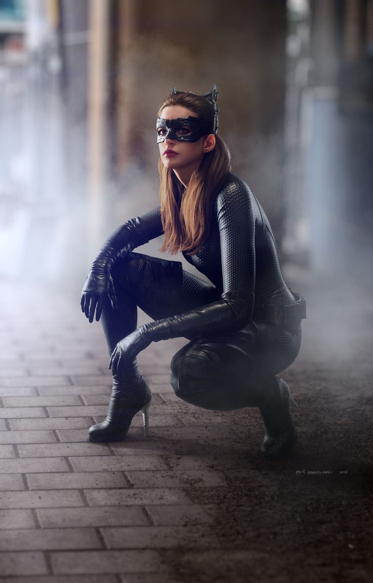 a woman dressed in a sleek, black catwoman costume crouches on a cobblestone street. she is wearing a black mask, a leather catsuit, and highheeled boots. her hair is long and dark, and she has a determined expression on her face. the background is an urban setting, with brick walls and smoke or fog adding to the atmosphere.