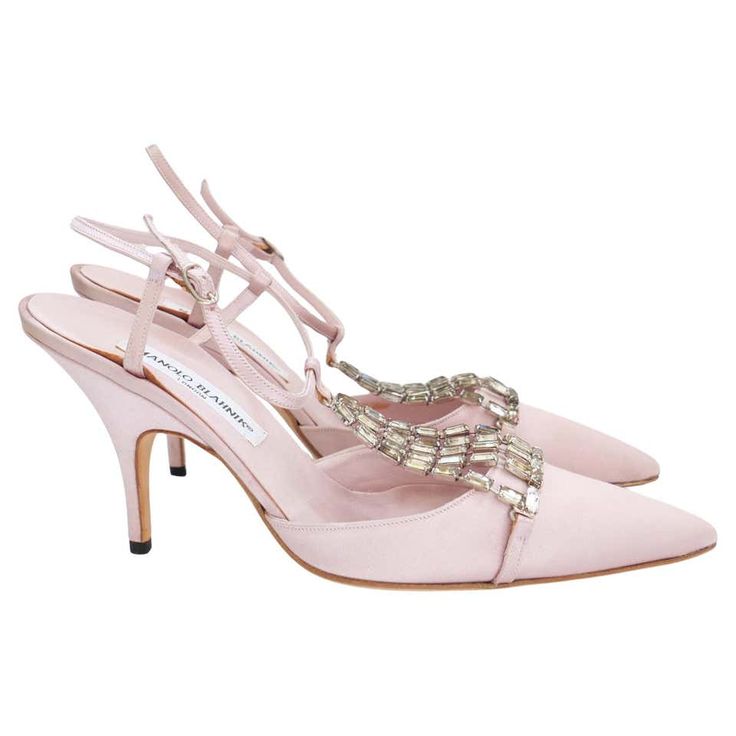 a pair of pink satin stiletto heels with crystal embellishments on the straps. the shoes have a pointed toe and are made of a silky material. they are perfect for a formal occasion.