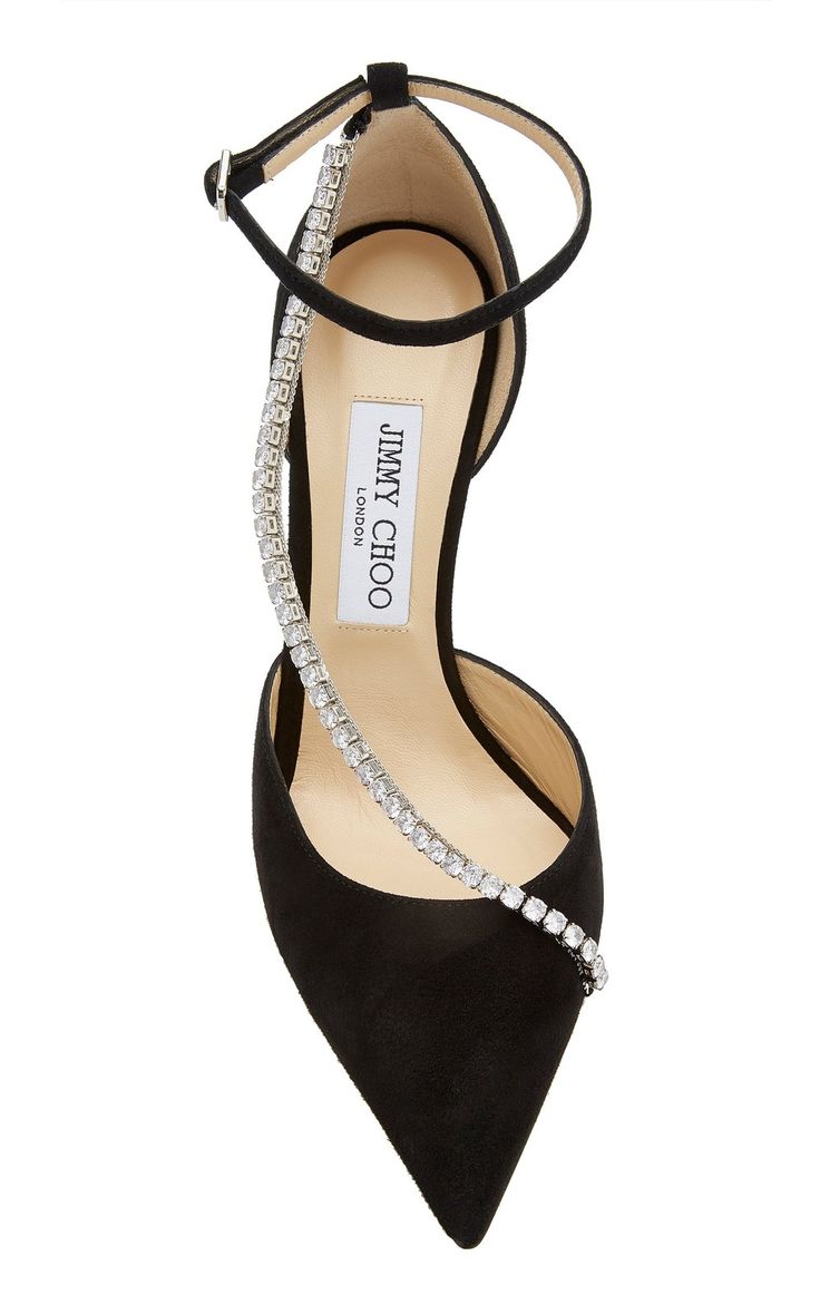 a closeup studio shot of a pair of jimmy choo black suede heels featuring a crystalembellished ankle strap. the shoes are elegantly styled with a pointed toe and a high heel, suitable for formal occasions. the jimmy choo label is visible on the insole. the image highlights the shoes' details, texture, and overall design.