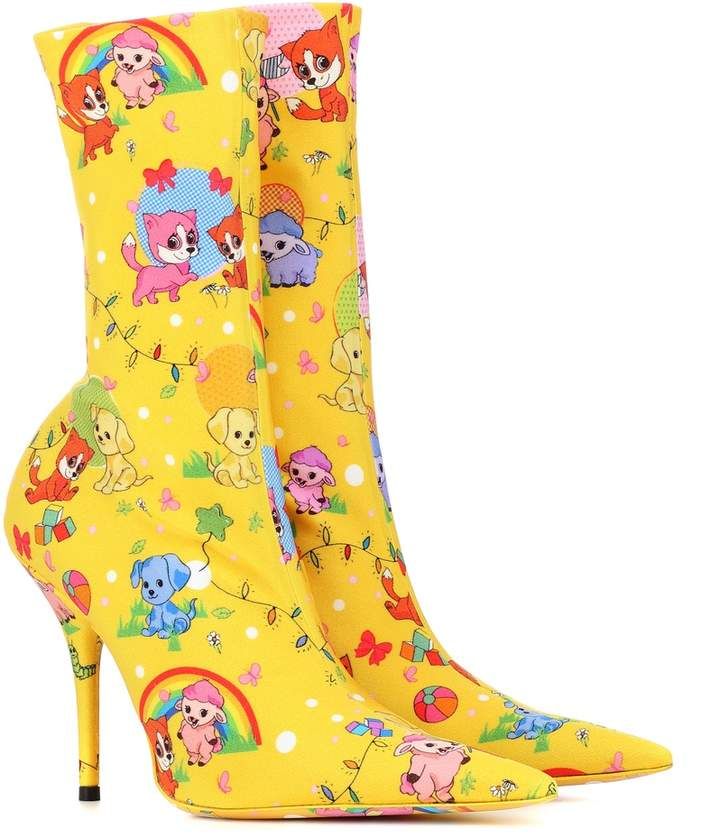 a pair of yellow highheeled boots with a cartoon animal pattern, including puppies, foxes, and lambs, with some rainbow and christmas light designs.