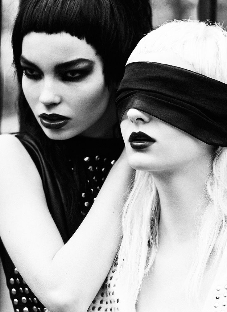 two women stand together in a black and white portrait, the