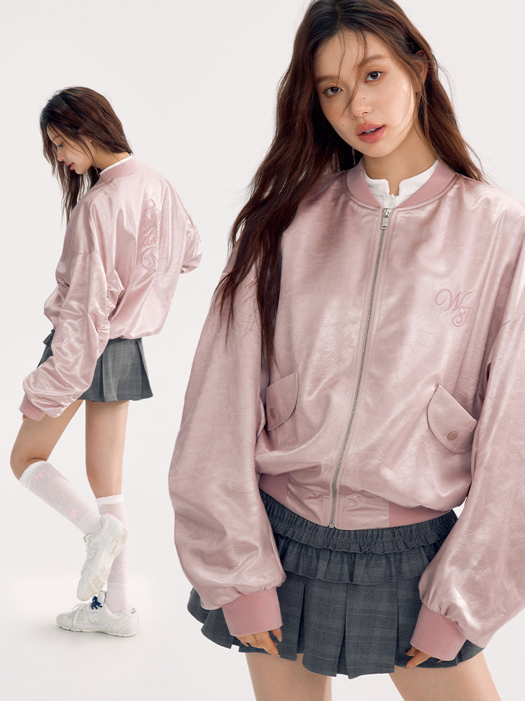 the image showcases two views of a young korean woman, likely a model, wearing a stylish ensemble. the main focus is on a pale pink, satin bomber jacket with an embroidered logo (possibly "mg"). the jacket is loosefitting with oversized sleeves.  she's also wearing a grey pleated mini skirt, white athletic socks, and white sneakers.  another view shows a similar figure from the back, showing the back of the jacket and skirt. the background is plain white, typical of a fashion photoshoot setting. the overall style is casual and trendy, reflecting contemporary korean fashion.