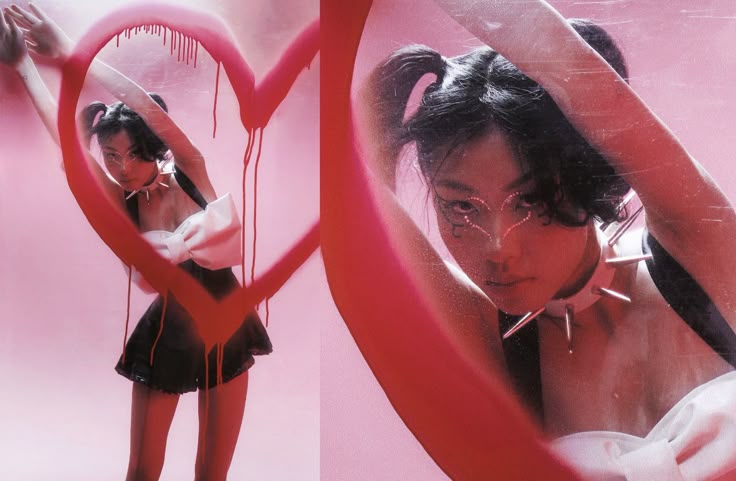 the image is a diptych, showing the same young woman in two slightly different poses.  she's styled in a dark and playful aesthetic blending elements of gothic lolita and punk. she wears a black and white minidress with a large white bow, a spiked choker, and has her dark hair in pigtails.  she's posed against a pink background with a large, dripping red heartshaped graffiti marking prominently featured in both images. one image shows her from more of a threequarter view, interacting with the graffiti, while the other is a closer, more focused portrait. the overall aesthetic is bold, contrasting, and visually striking.