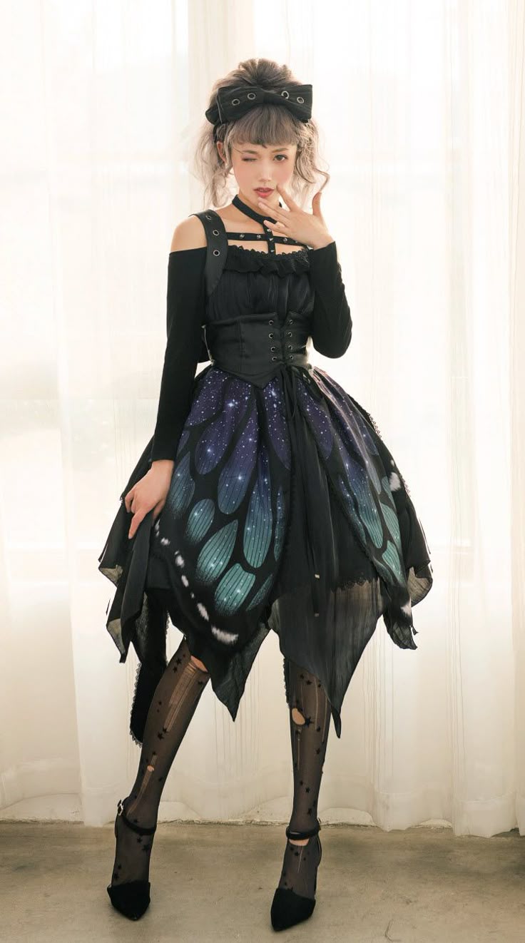 a woman is standing in front of a window wearing a black dress with butterfly wing details, dark tights, and shoes. she is winking with one eye closed and has a bow in her hair. she is also wearing straps across her chest. the dress has a tulle skirt with a butterfly wing print.