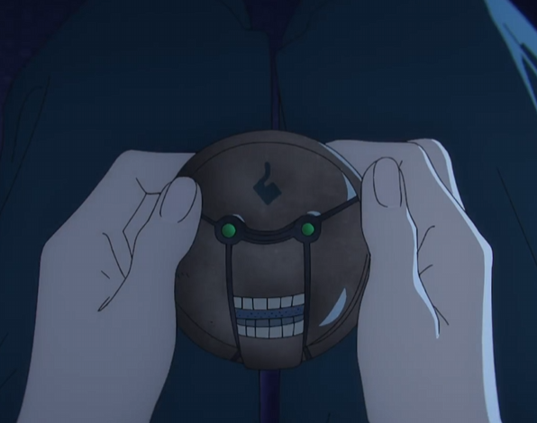 pair of hands is shown holding a circular mechanical object in front of a dark blue garment. the object has two glowing green eyes, a smiling mouth with teeth, and a dark brown textured surface. a stylized 's' symbol is embossed on the top. the overall scene is dimly lit with an emphasis on the object.