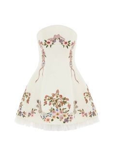 a white strapless dress with floral embroidery and applique. the dress has a ruffle at the bottom and a skirt with a flowing silhouette. it is perfect for a summer wedding or a special occasion.